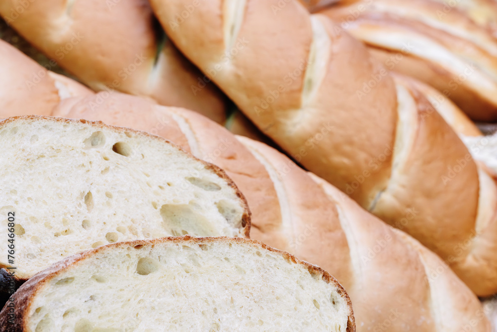 Poster a close up of a loaf of bread with a few slices missing. the bread is white and has a slightly brown
