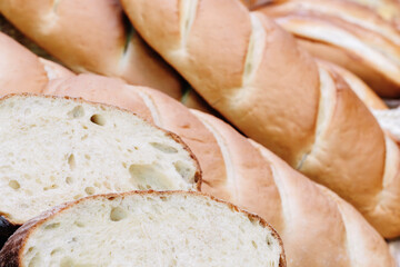 A close up of a loaf of bread with a few slices missing. The bread is white and has a slightly brown crust. The slices are cut in half, revealing the soft, fluffy interior
