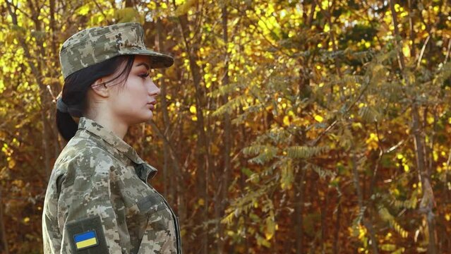 Female servicewoman brave confident soldier dressed in the camouflage military uniform, velcro patch symbol of independence. Armed Forces of Ukraine. Woman serving in ukrainian army troops
