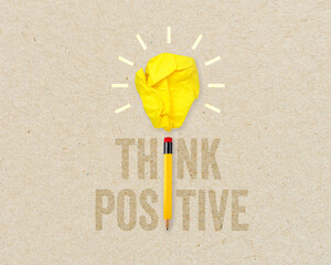 Yellow paper light bulb metaphor for creative and think positive with pencil on brown recycled background