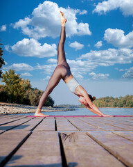 Woman in downward facing dog pose practicing yoga outdoor - 766470874