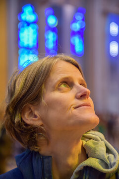 blue eyes woman looking up inside a church with glassworks in the background