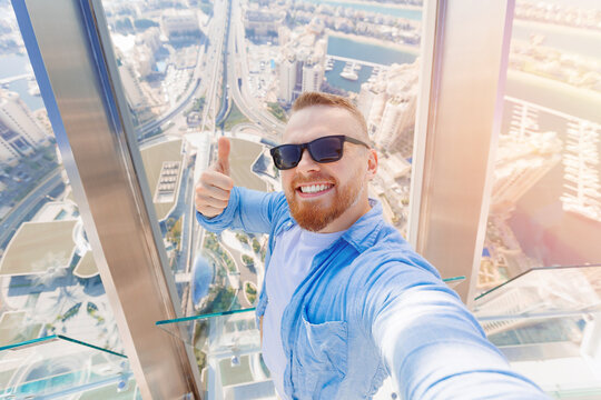 Selfie photo of happy man tourist on background skyscrapers in Dubai on view point. UAE business tourism for cryptocurrency concept