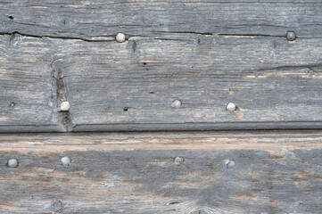 Very old grunge, weathered, knotty wooden planks with metal nails. Background image