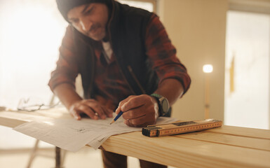 Designing and marking blueprints for home improvement: Professional remodeler renovating a kitchen