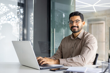 Focused Indian businessman using laptop at the office. Concept of professionalism and modern...