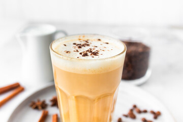 Coffee latte in glass with cinnamon, spices and roasted coffee beans. Creamy coffee with milk....