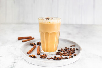 Coffee latte in glass with cinnamon, spices and roasted coffee beans. Creamy coffee with milk....