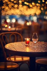 An empty table at a restaurant with a candle and wine glass on it