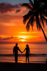Couple holding hands walking on beach at sunset
