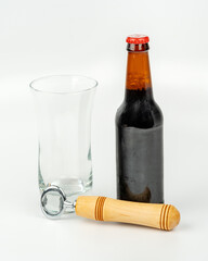 Bottle of beer with bottle opener and glass