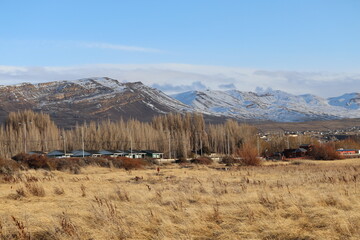 The landscape of  El Calafate showing the Patagonian Steppe with a snowy mountain range in the background.