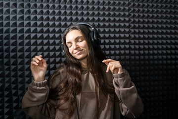 Smiling Woman Enjoying Music in a Professional Studio With Acoustic Foam Walls - 766503252