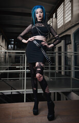 Indoor portrait of sexy goth (deathrock) girl dressed in black skirt, holey blouse and pantyhose. Dark beauty