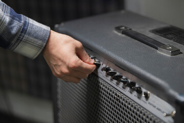 Guitarist Fine-Tunes Amplifier Settings Before a Performance in a Backstage Area
