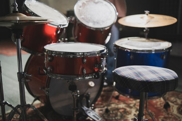 Close-Up View of a Red Acoustic Drum Set With Cymbals and Stool in a Music Studio