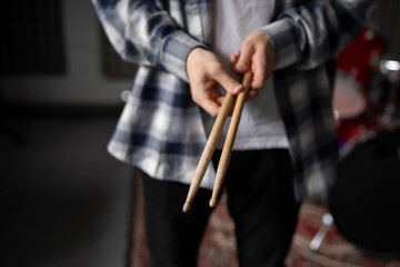 Drummer hands Holding Drumsticks While Standing in a Rehearsal Studio - 766503693