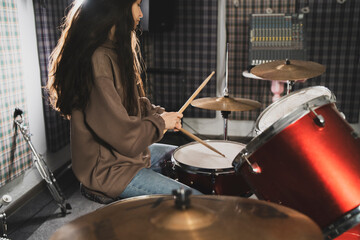 Smiling Woman Playing Drums Enthusiastically in a Music Studio Setting - 766505279