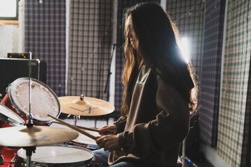 Smiling Woman Playing Drums Enthusiastically in a Music Studio Setting - 766505420