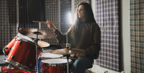 Energetic Female Drummer Enjoys Playing Red Drum Kit in a Casual Setting - 766506056