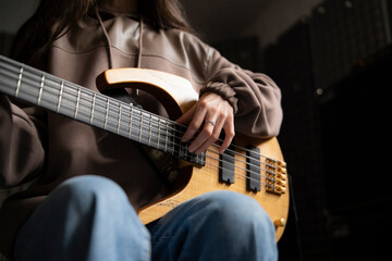 Close-Up View of a Musician Playing a Bass Guitar During an Indoor Session - 766506431