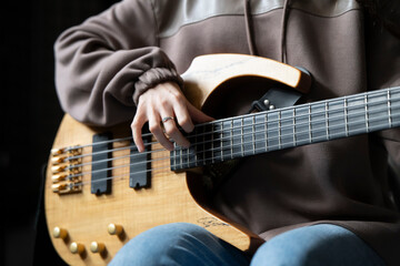 Close-Up View of a Musician Playing a Bass Guitar During an Indoor Session - 766506436