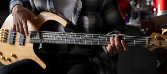 Close-Up View of a Musician Playing a Bass Guitar During an Indoor Session - 766506467