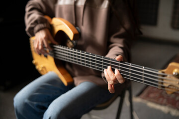 Close-Up View of a Musician Playing a Bass Guitar During an Indoor Session - 766506470