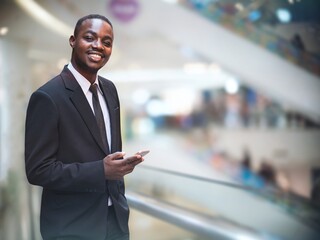 African business man in suit using smartphone with smile and happy