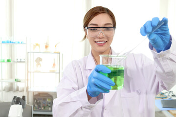 Portrait of happy beautiful Asian scientist woman in lab coats with safety glasses do science...