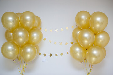 mother of pearl gold balloons with gold ribbons and a garland of gold stars