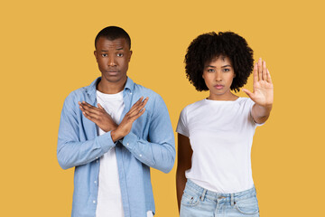 Serious African American man and woman making stop gestures with their hands