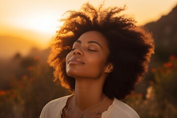 Retrato en primer plano de hermosa mujer negra respirando aire fresco durante un hermoso atardecer. Calma y relajación. - obrazy, fototapety, plakaty