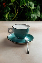 Cappuccino coffee cup, Against a backdrop of green plants