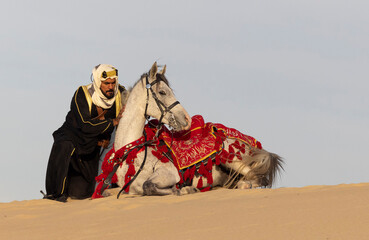 Saudi Man with his white stallion in a desert