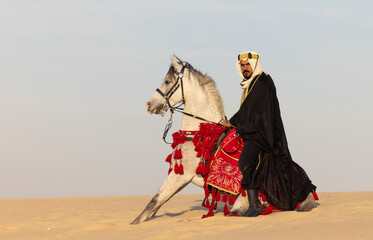 Obraz premium Saudi Man with his white stallion in a desert