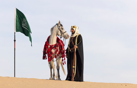 Saudi Man with his white stallion in a desert