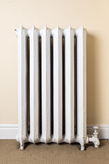 old fashioned steam or hot water heating white painted cast iron radiator in an old residence