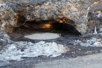 Metal sewer hatch under dirty snow. Thawing snowdrifts in winter.