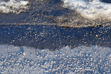 Crumbs of anti-icing mixture on the road, clearing icing.