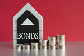 Symbol for increasing Bonds. Text Bonds written on a black board. Silver coins arranged in a graph...