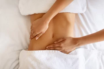 Foto op Plexiglas Unrecognizable young woman receiving massage therapy for abdominal area indoor © Prostock-studio