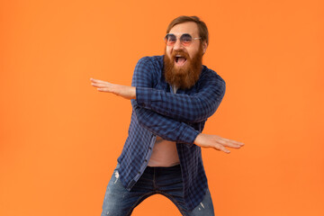 Positive redhaired man with beard dancing making funny moves, studio