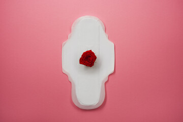 Menstrual pad with red rose on pink background