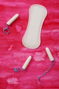 Hygienic pad and tampons on a pink background