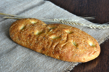 a loaf of bread with seeds on burlap napkin isolated  