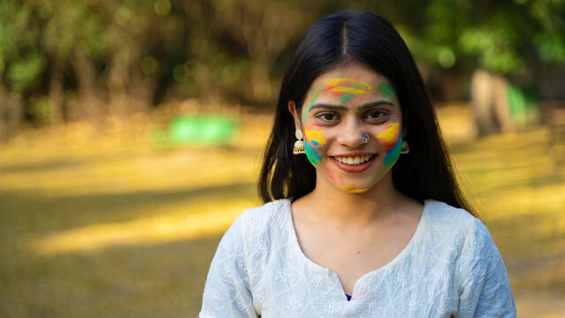 Woman celebrating Holi festival with powder colours or gulal, Holi celebration outdoor