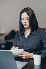 Fototapeta premium Emotional conversation of young woman on video call through laptop. Lifestyle workplace in cafe.
