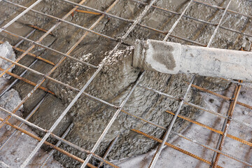 Closeup pipe of pump truck move concrete to reinforced structures, foundation of floor with Iron...