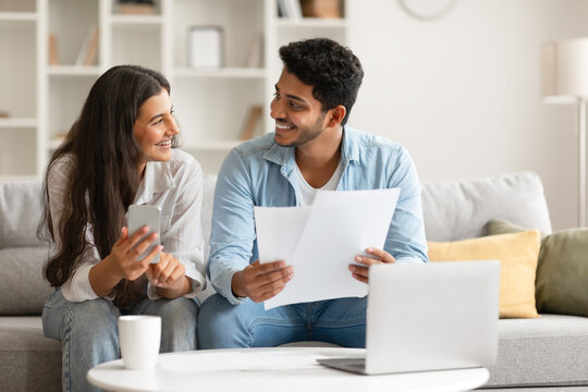 Hindu couple planning finances with documents and laptop